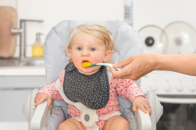 Piccola neonata sveglia in una cucina