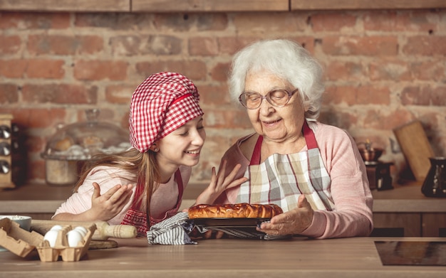 Piccola nipote con la nonna che gode della torta di frutta casalinga