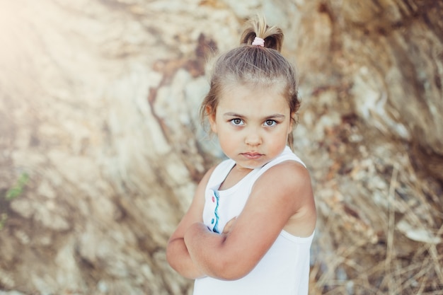 Piccola ragazza adorabile che propone all'aperto