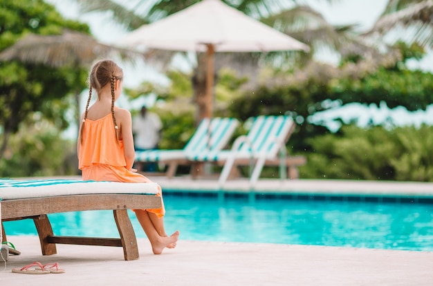 Piccola ragazza adorabile felice nella piscina all&#39;aperto