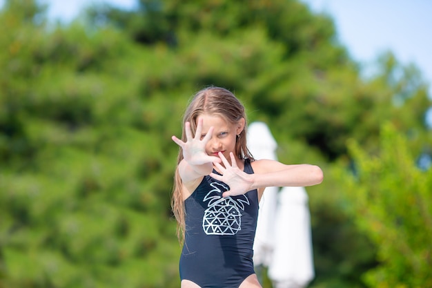 Piccola ragazza adorabile nella piscina all'aperto