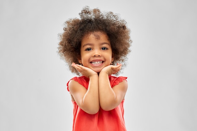 Piccola ragazza afroamericana felice sopra il grigio