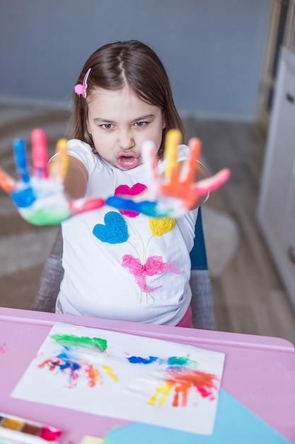 Piccola ragazza allegra allegra sveglia adorabile che disegna da solo a casa durante la vacanza o la quarantena. Attività a casa dell'infanzia a casa, arte per bambini