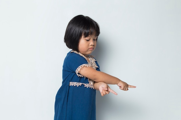 Piccola ragazza asiatica che indica con le dita in direzioni diverse Copia spazio per la pubblicità