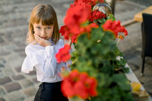 Piccola ragazza bionda che posa alla macchina fotografica