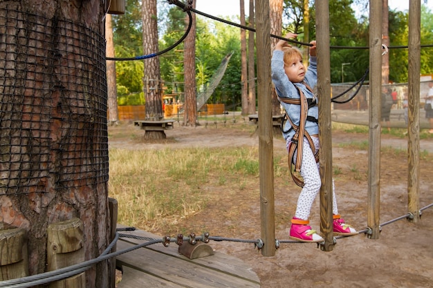 Piccola ragazza bionda che si diverte nel parco giochi