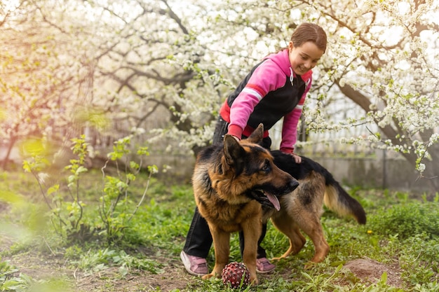 Piccola ragazza carina che abbraccia e riposa il cane.