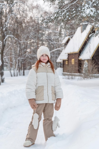Piccola ragazza carina in inverno cammina nella foresta coperta di neve in inverno Attività invernali Pastime Walk