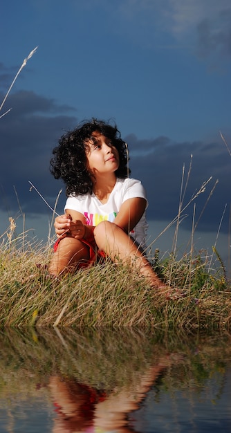 Piccola ragazza carina prima della notte sul prato