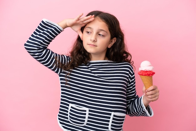 Piccola ragazza caucasica che tiene un gelato isolato su sfondo rosa che sorride molto