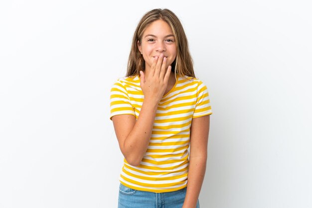 Piccola ragazza caucasica isolata su sfondo bianco felice e sorridente che copre la bocca con la mano