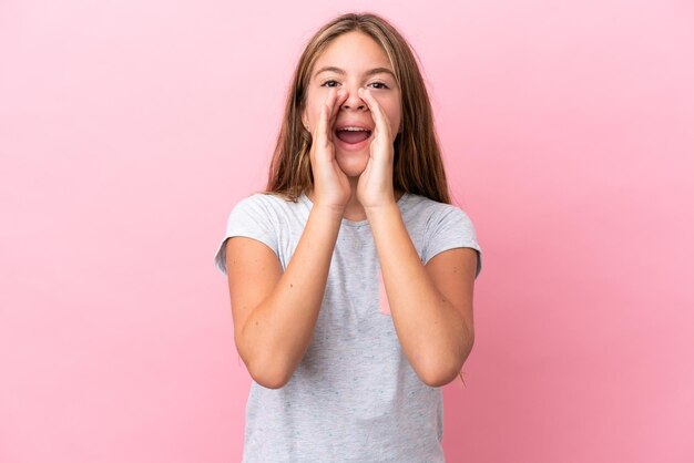 Piccola ragazza caucasica isolata su sfondo rosa che grida e annuncia qualcosa