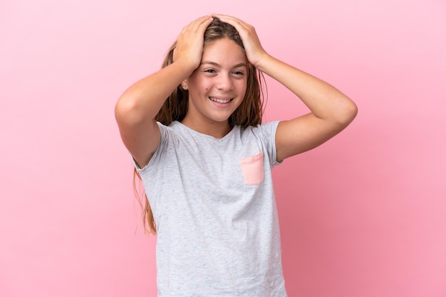 Piccola ragazza caucasica isolata su sfondo rosa che ride