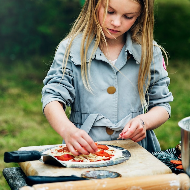 Piccola ragazza che cucina concetto di pizza