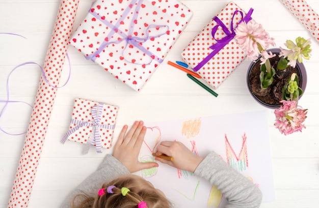 Piccola ragazza che disegna un biglietto di auguri