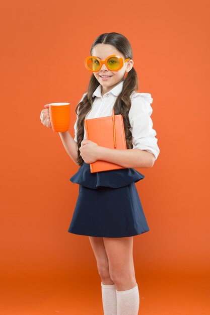 Piccola ragazza che si diverte a scuola Piccola scolaretta felice pronta per la lezione Bambino carino con libro Studiare una lingua straniera Fare pausa tè all'ora di pranzo Studiare letteratura Agli studenti piace studiare