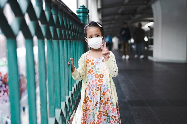 piccola ragazza con maschera protettiva che guarda l'obbiettivo.