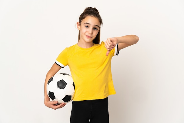Piccola ragazza del giocatore di football isolata su fondo bianco che mostra il pollice verso il basso con l'espressione negativa