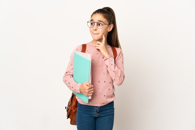 Piccola ragazza dell'allievo sopra fondo isolato che ha dubbi e pensiero