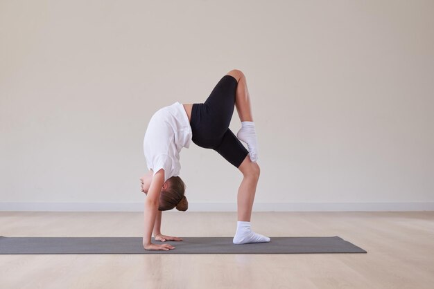 Piccola ragazza esegue esercizi in una classe di ginnastica sportiva Il concetto di sport Pilates stretching stile di vita sano Media misto