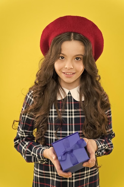 Piccola ragazza in cappello stile francese ragazza felice con lunghi capelli ricci in berretto buon compleanno Regalo di festa shopping bambino con scatola regalo bambino parigino su sfondo giallo Qualità perfetta