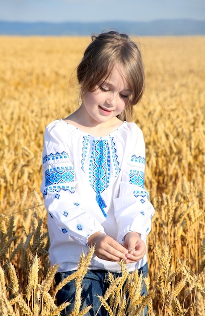 Piccola ragazza rurale sul campo di grano