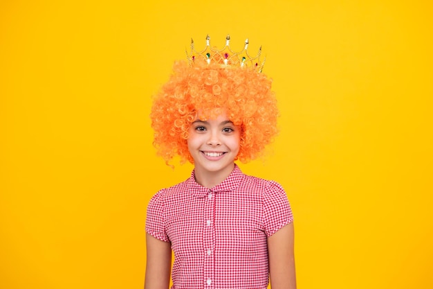 Piccola regina in parrucca che indossa la corona d'oro Principessa della ragazza adolescente che tiene il diadema della corona Concetto di infanzia della festa di ballo di fine anno