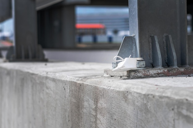 Piccola scarpa bianca per bambini legata al bullone di fissaggio della recinzione di sicurezza sull'autostrada