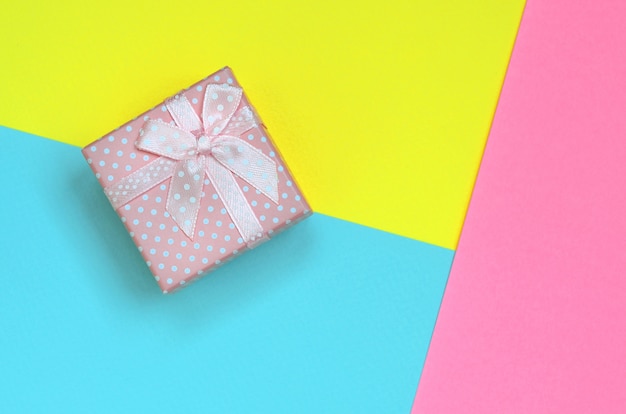 Piccola scatola regalo rosa si trovano sulla trama colorata