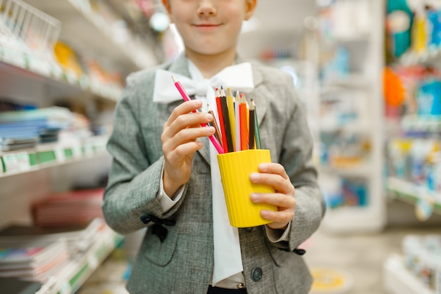 Piccola studentessa con matite colorate, shopping in cartoleria