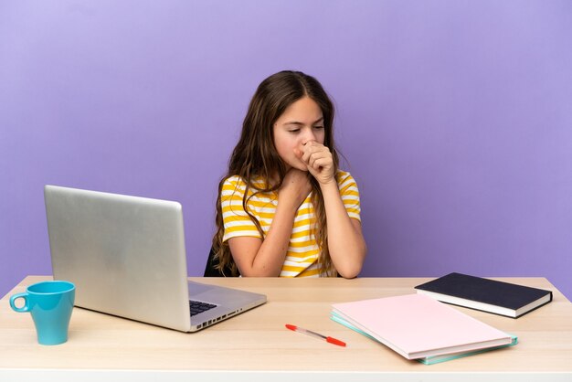 Piccola studentessa in un posto di lavoro con un laptop isolato su sfondo viola che tossisce molto a