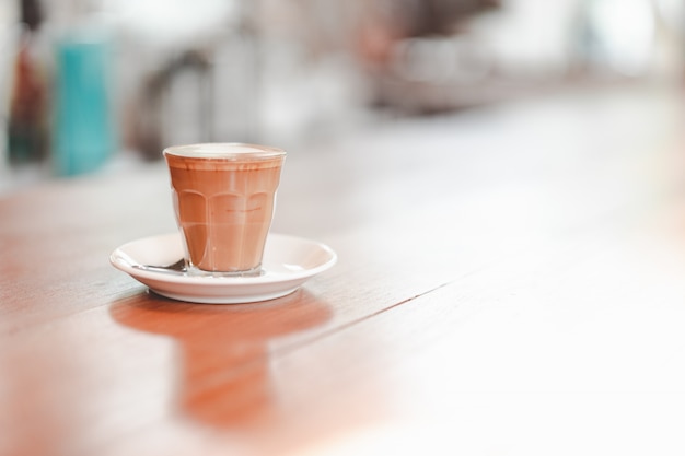 Piccola tazza di latte piccolo servita sul tavolo di legno