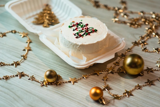 Piccola torta bento bianca con decorazione dell'albero di natale nella tabella Foto dell'atmosfera natalizia per il contenuto della pasticceria