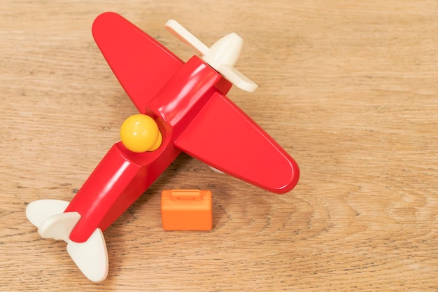 piccola valigia e aereo giocattolo sul vecchio tavolo di legno