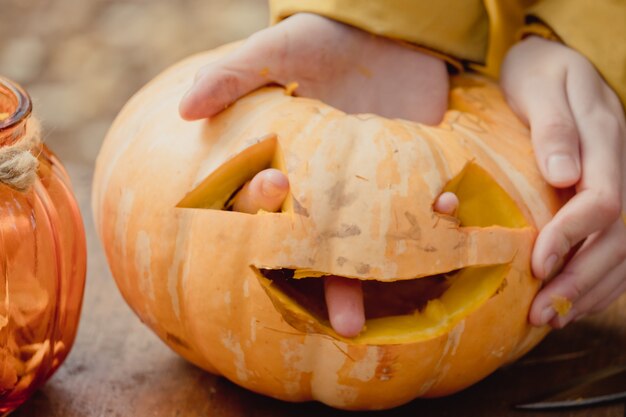 Piccola zucca arancione, jack-o-lantern su tavola di legno