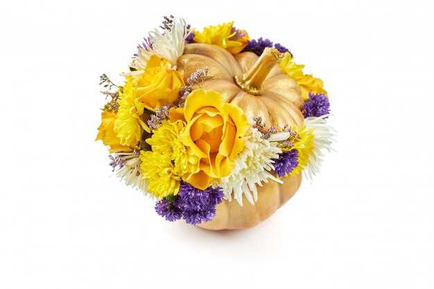 Piccola zucca dorata decorata con fiori gialli e blu come regalo su uno sfondo bianco