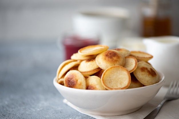 Piccole frittelle con frutti di bosco, marmellata e zucchero a velo