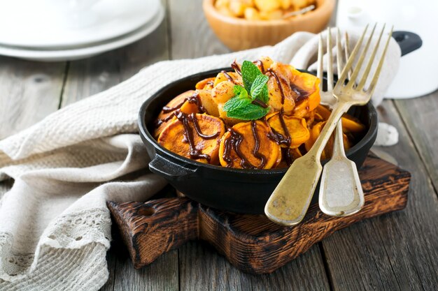 Piccole frittelle di zucca con salsa al cioccolato in padella sulla vecchia annata