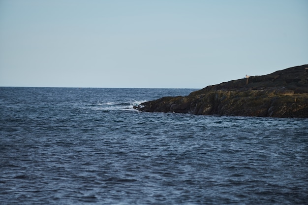 Piccole onde del mare si infrangono contro le pietre della riva.