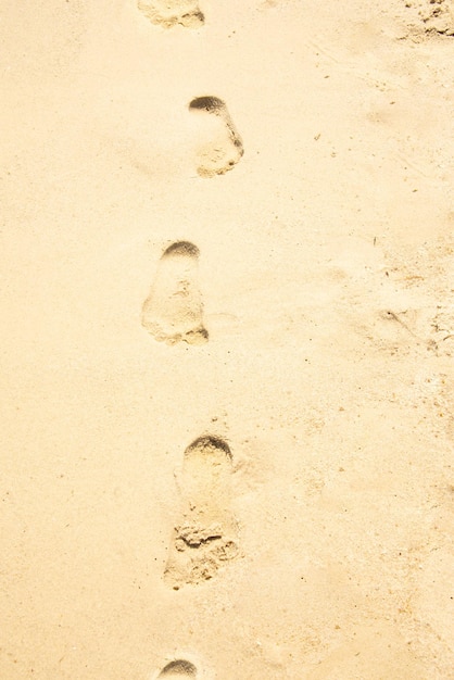 Piccole orme del bambino sulla sabbia della spiaggia