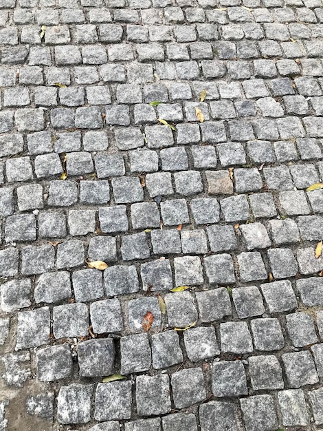 Piccole vecchie mattonelle di pietra sullo sfondo del terreno