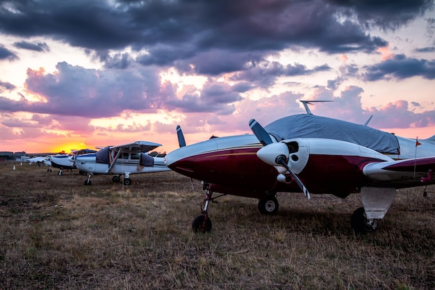 Piccoli aerei privati parcheggiati all'aeroporto al tramonto pittoresco