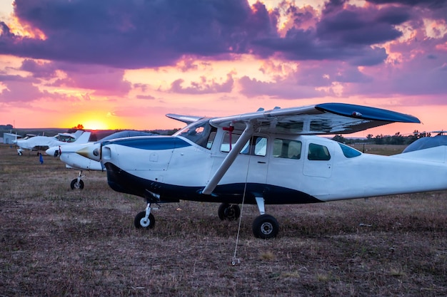 Piccoli aeroplani privati parcheggiati all'aeroporto al tramonto panoramico