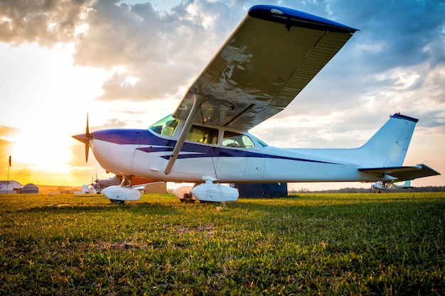 Piccoli aeroplani privati sull'aerodromo sullo sfondo di un tramonto colorato