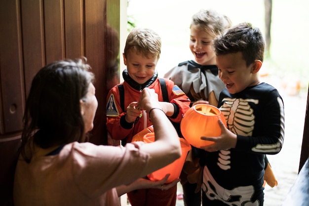 Piccoli bambini che fanno trucchi o dolcetti ad Halloween