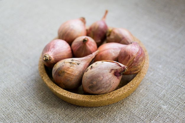 Piccoli bulbi di cipolla rosa in un piatto