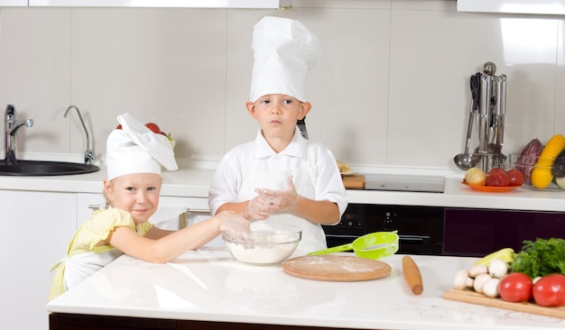 Piccoli chef carini che cuociono la pizza in cucina