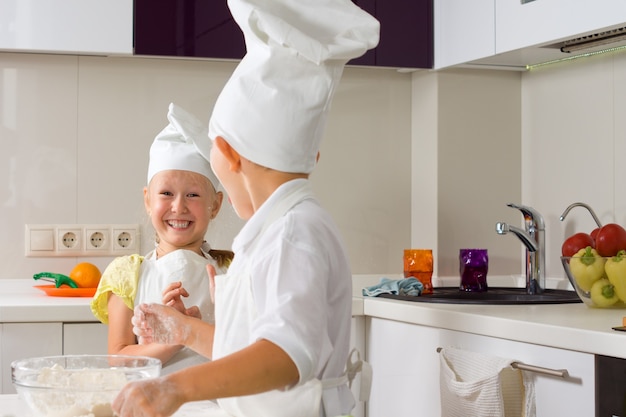 Piccoli chef molto felici che preparano qualcosa da mangiare in cucina.