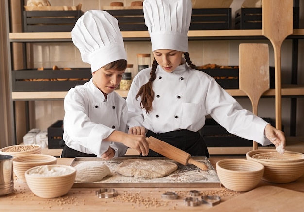 Piccoli fornai che preparano la pasta sul tavolo