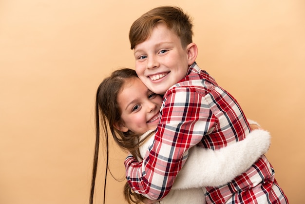 Piccoli fratelli caucasici isolati sul muro beige